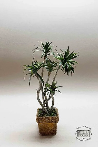 Planta Dracanea con maceta en miniatura escala 1:12. Pieza única para casas de muñecas y coleccionistas realizada por la artesana miniaturista Desirée Lafuente.